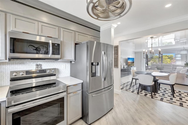 kitchen with a notable chandelier, light countertops, decorative backsplash, gray cabinetry, and appliances with stainless steel finishes