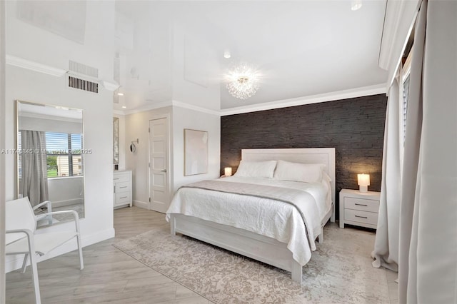 bedroom with ornamental molding, an accent wall, visible vents, and baseboards