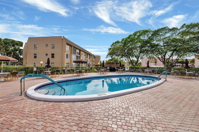 pool with a patio area and fence