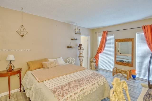 bedroom with light wood-type flooring and baseboards