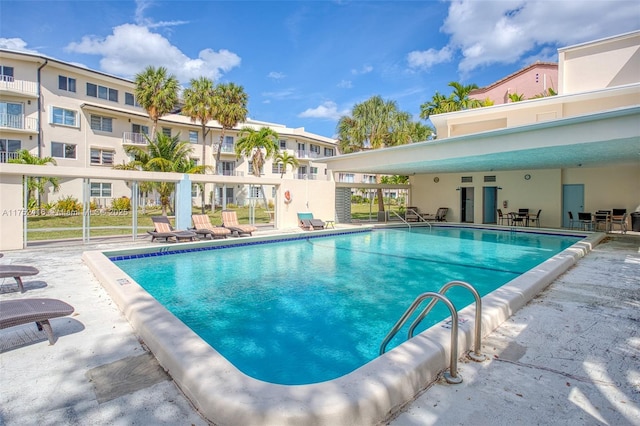 community pool featuring a patio area and fence