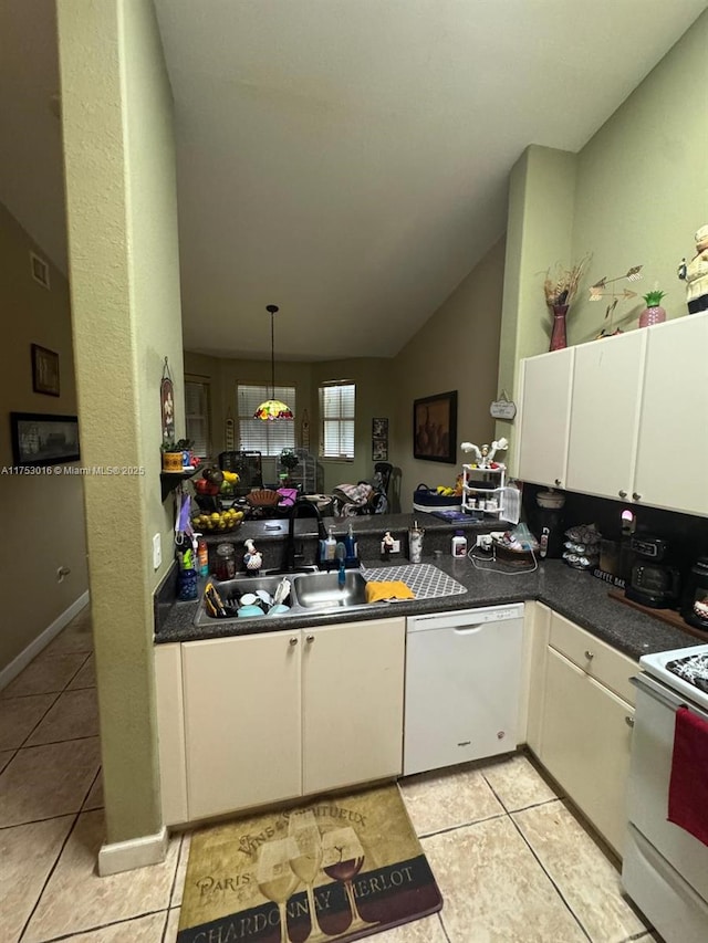 kitchen with dark countertops, white appliances, white cabinetry, and a sink