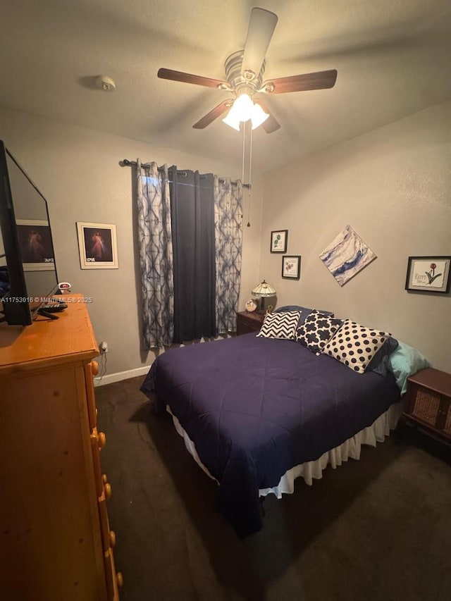 bedroom featuring dark colored carpet, a ceiling fan, and baseboards