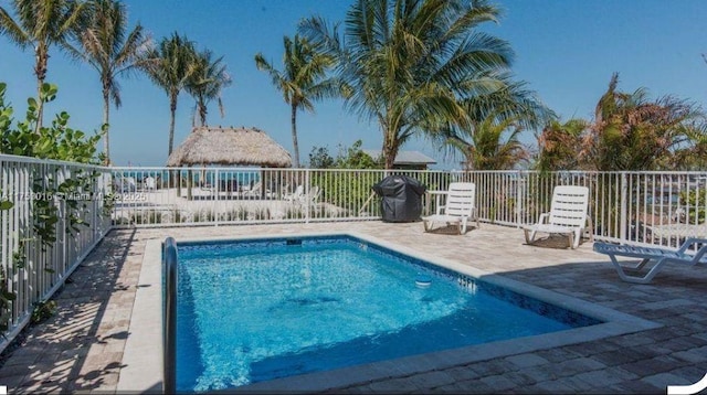 community pool with a patio and fence