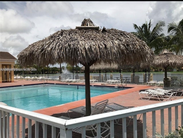 pool with a patio and fence