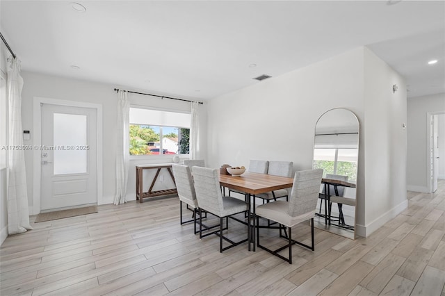 dining room with light wood finished floors, baseboards, visible vents, and recessed lighting