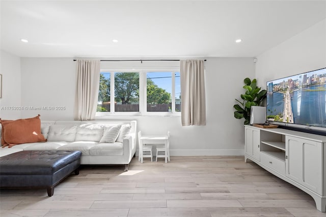 living room featuring light wood-style flooring, baseboards, and recessed lighting