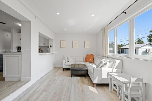 living room featuring light wood-style floors, baseboards, visible vents, and recessed lighting