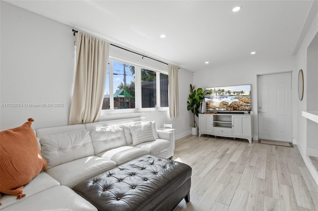 living room featuring light wood finished floors, baseboards, and recessed lighting