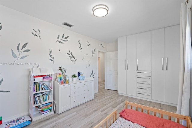 bedroom featuring light wood-style floors and visible vents