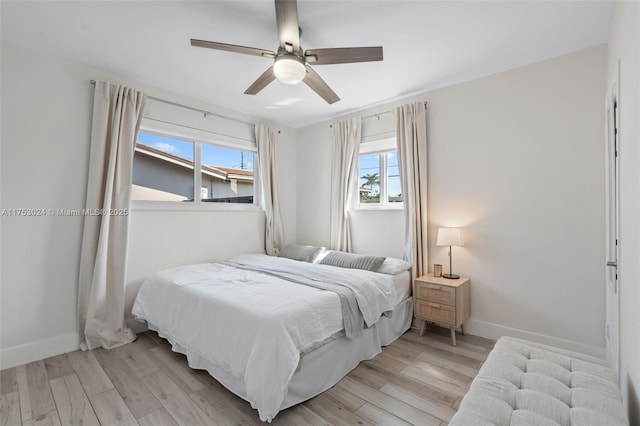 bedroom with ceiling fan, light wood-type flooring, and baseboards