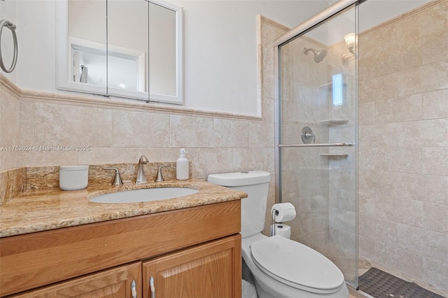 full bath featuring tiled shower, vanity, toilet, and tile walls