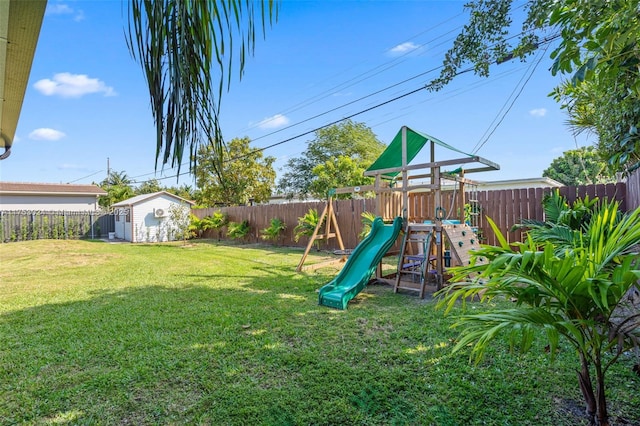 view of playground with a fenced backyard, a storage unit, an outdoor structure, and a yard