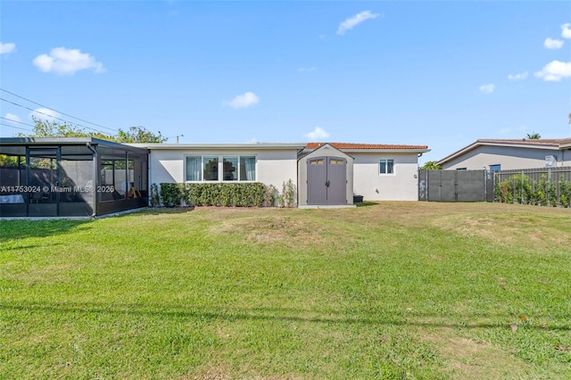 view of front of home featuring a storage shed, a front yard, fence, and stucco siding