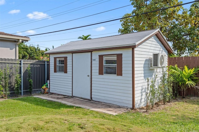 view of outdoor structure featuring fence and an outbuilding