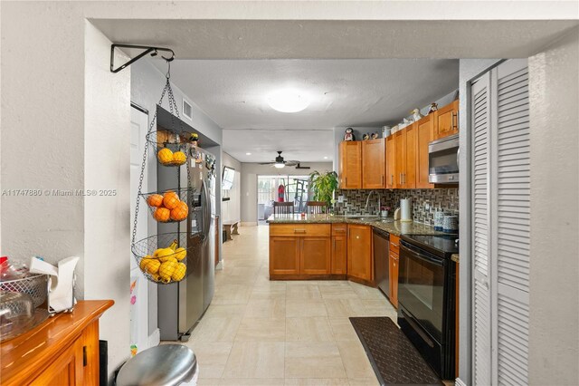 1089 SW 135th Pl, Miami, FL 33184 - kitchen with backsplash, appliances with stainless steel finishes, brown cabinetry, a sink, and a peninsula