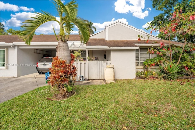 view of front of home featuring a front yard, an attached carport, and stucco siding