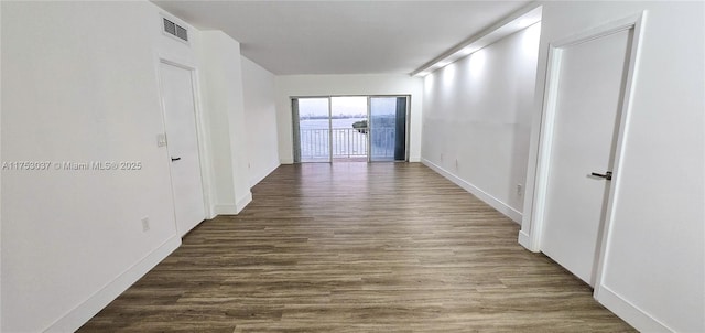 hallway featuring visible vents and wood finished floors