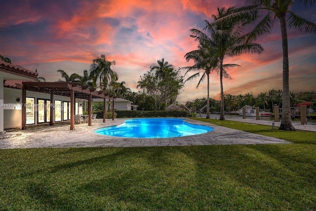 pool featuring a patio area, a lawn, and a pergola