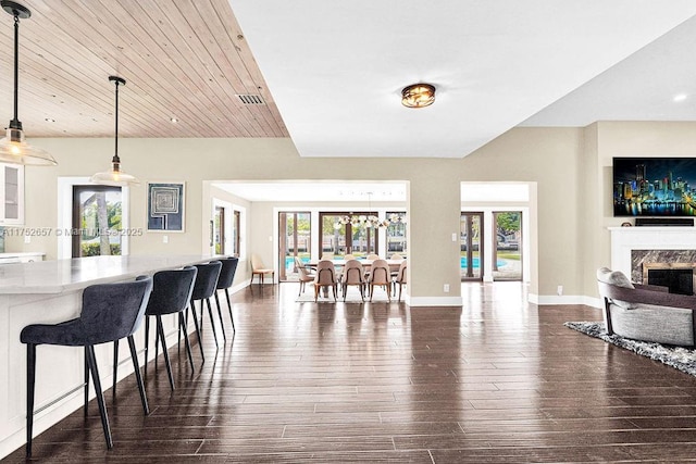 interior space featuring dark wood finished floors, a high end fireplace, and a healthy amount of sunlight