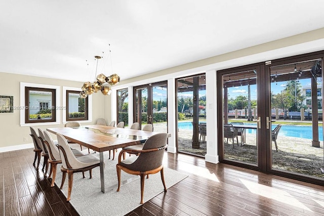 dining area with a notable chandelier, baseboards, wood finished floors, and french doors