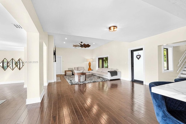 living area with a wealth of natural light, stairway, and dark wood-type flooring