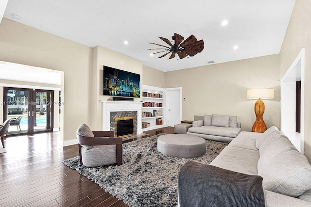 living room with french doors, visible vents, a premium fireplace, wood finished floors, and baseboards