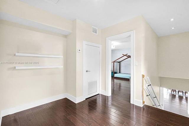 empty room with dark wood-type flooring, recessed lighting, visible vents, and baseboards