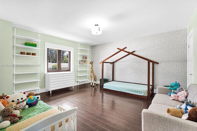 bedroom with dark wood finished floors, baseboards, and wallpapered walls