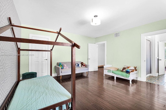 bedroom with dark wood-style floors, visible vents, and baseboards