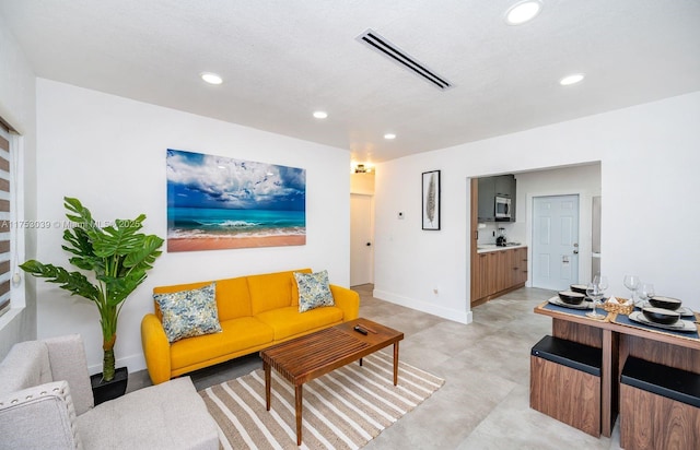 living room with baseboards, concrete floors, visible vents, and recessed lighting