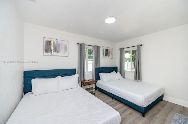 bedroom with baseboards and wood finished floors