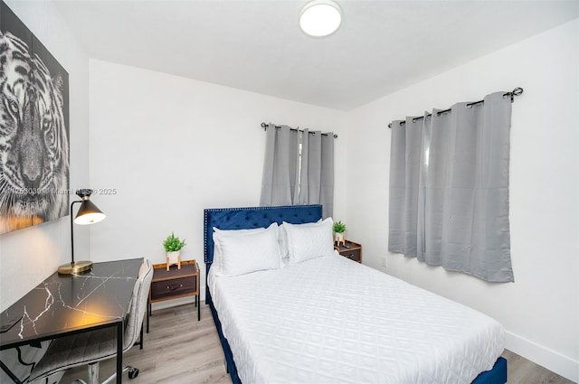 bedroom with baseboards and wood finished floors