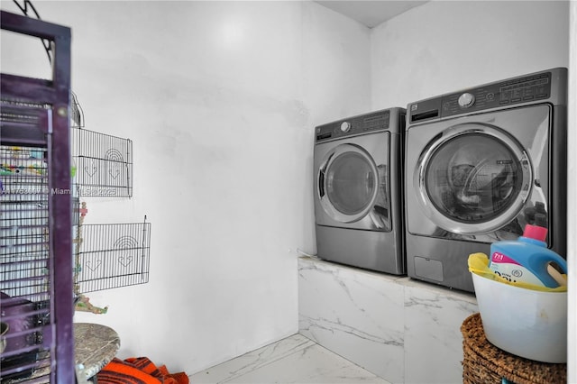 laundry room featuring marble finish floor, laundry area, and separate washer and dryer