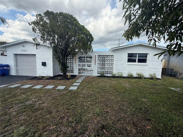 view of side of property with a garage, a yard, driveway, and stucco siding