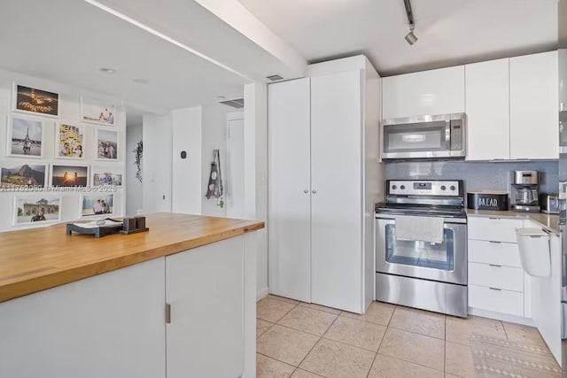 kitchen featuring light tile patterned floors, appliances with stainless steel finishes, modern cabinets, and white cabinetry