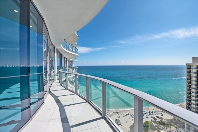 balcony featuring a water view and a beach view