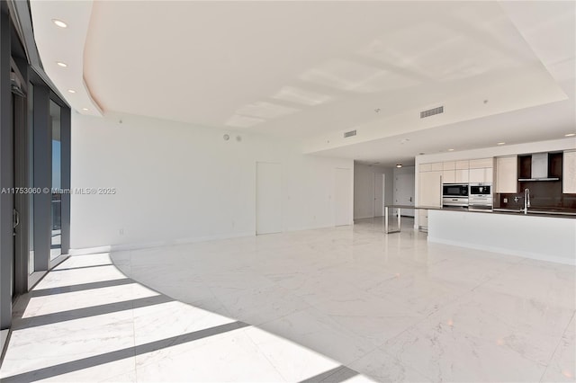 unfurnished living room featuring marble finish floor, recessed lighting, visible vents, and baseboards