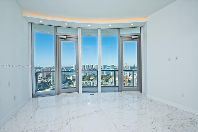 spare room with baseboards, floor to ceiling windows, and a city view