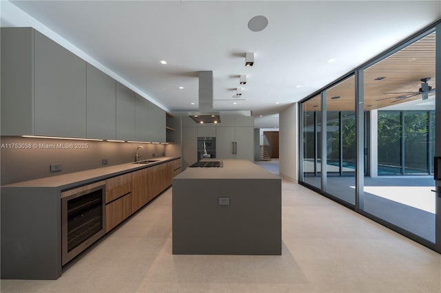 kitchen featuring beverage cooler, expansive windows, modern cabinets, and a sink