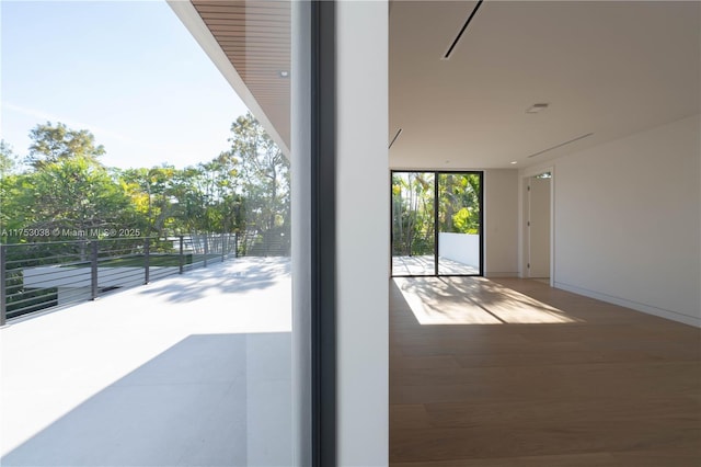 doorway with floor to ceiling windows and wood finished floors