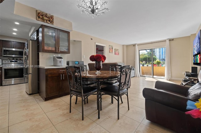 dining space featuring light tile patterned floors and an inviting chandelier