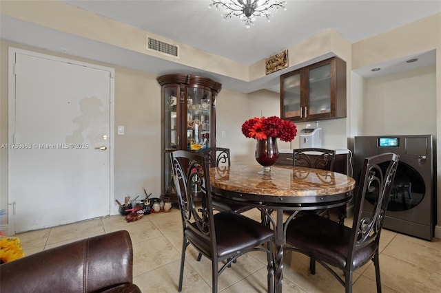 dining space featuring washer / clothes dryer, visible vents, and light tile patterned floors