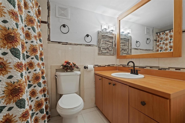 full bathroom featuring visible vents, toilet, tile patterned floors, vanity, and tile walls