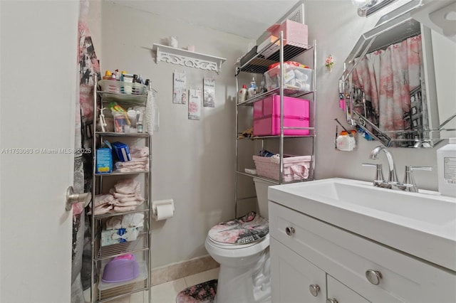 bathroom featuring vanity, tile patterned flooring, and toilet