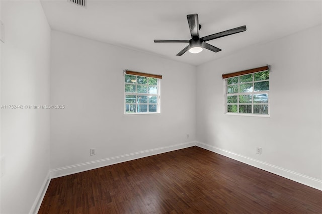 unfurnished room with a ceiling fan, dark wood finished floors, and baseboards