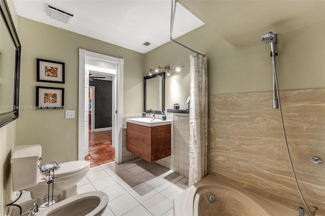 bathroom with visible vents, toilet, a bidet, vanity, and tile patterned flooring