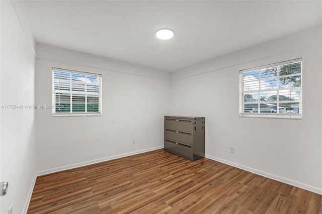 empty room featuring baseboards and wood finished floors