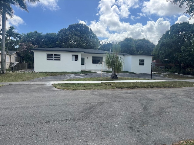 view of front of home with fence, a front lawn, and stucco siding