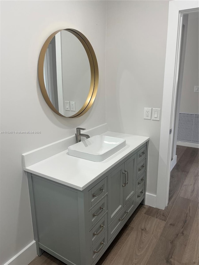 bathroom with baseboards, visible vents, wood finished floors, and vanity